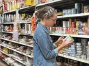 woman in grocery store looking at food item