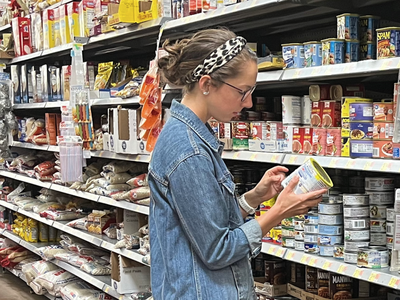 woman in grocery store looking at food item