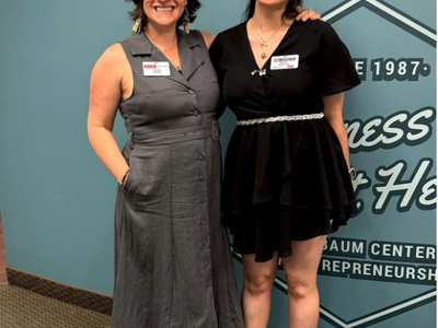 Two women standing in front of a wall reading "Nussbaum Center for Entrepreneurship."