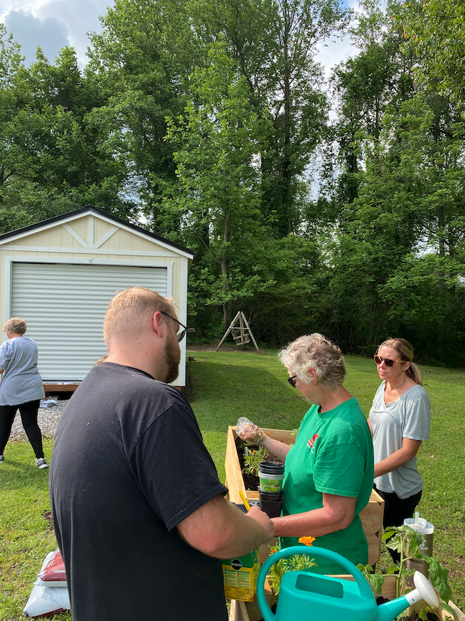 Volunteers help plant a salsa garden at a senior center.