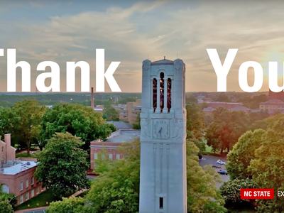 An aerial image of the NC State Memorial Belltower at sunrise, with "Thank You" displayed in text across the top of the image.