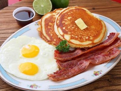 A full breakfast of eggs, pancakes and bacon.