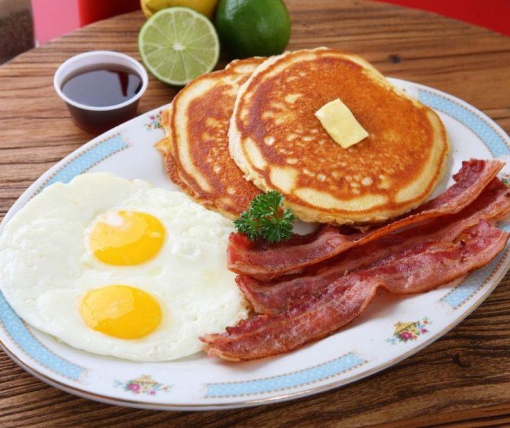 A full breakfast of eggs, pancakes and bacon.