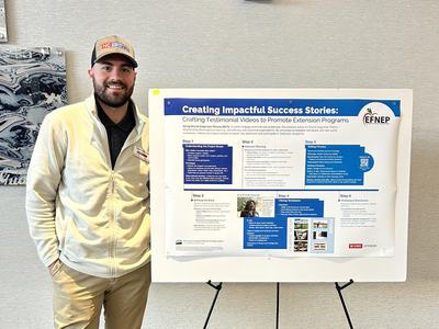 Man standing beside poster titled "Creating Impactful Success Stories: Crafting Testimonial Videos"