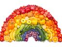 Fruits and vegetables arranged in a rainbow arc by color on a white background
