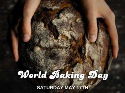 two hands holding a loaf of artisan bread with a dark, shadowed background