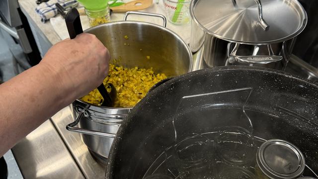Filling jars with relish and home canning in water bath canner