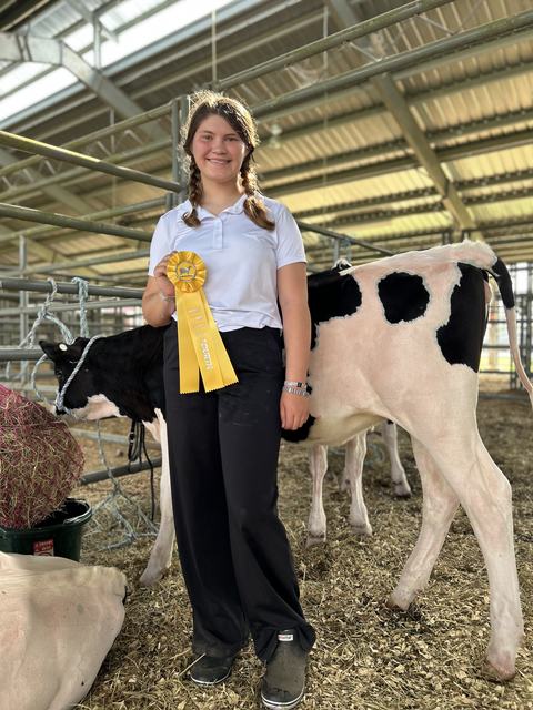 Emma Kate Van Domelen with her dairy calf, displaying her fourth place ribbon