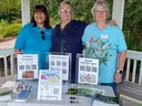 Three Master Gardener volunteers at info table labeled "Extension Master Gardeners."