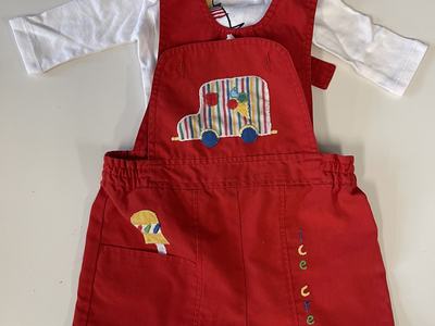 A white shirt with red overalls for a toddler.