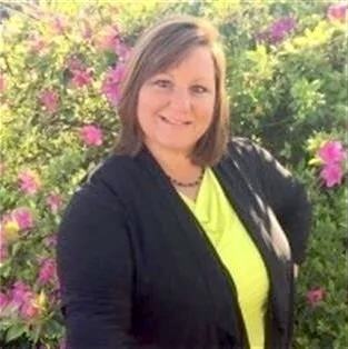 Photo of Dr. Kim Ingold with pink flowers around her.