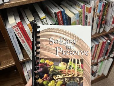 image of So Easy To Preserve book held in front of a bookcase
