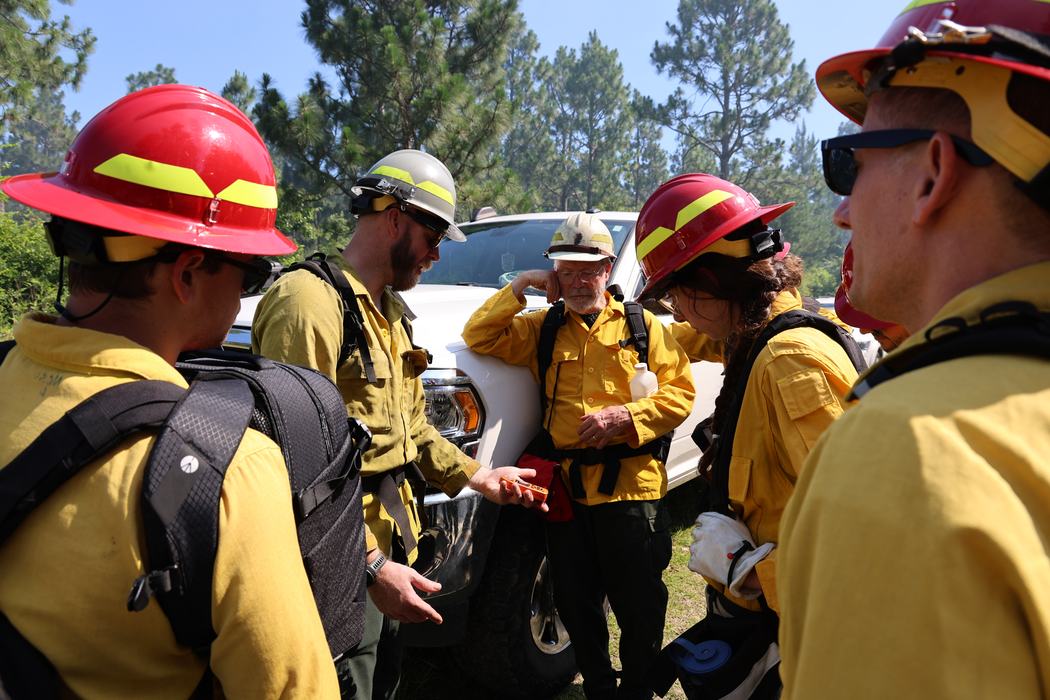 Fire Week participants learn how to use a Kestrel Fire Weather Meter to measure weather during a prescribed burn with The Nature Conservancy.