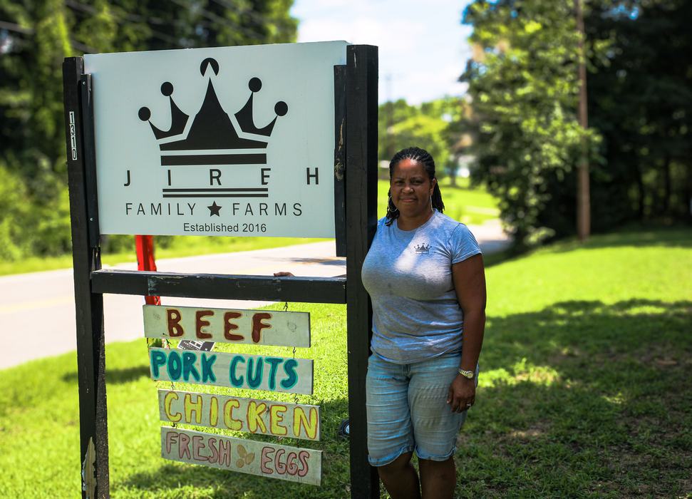 Valerie Jarvis standing with the Jireh Family Farms sign