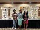 Three girls—two in dresses and one in jeans—standing in front of large 'NC 4-H' letters at NC 4-H Congress.