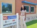 A woman standing by a sign that reads NC Cooperative Extension, Bertie County Center