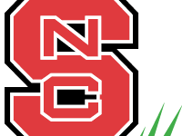 Red block "S" with interlocked white "NC" inside, three green grass blades at lower right