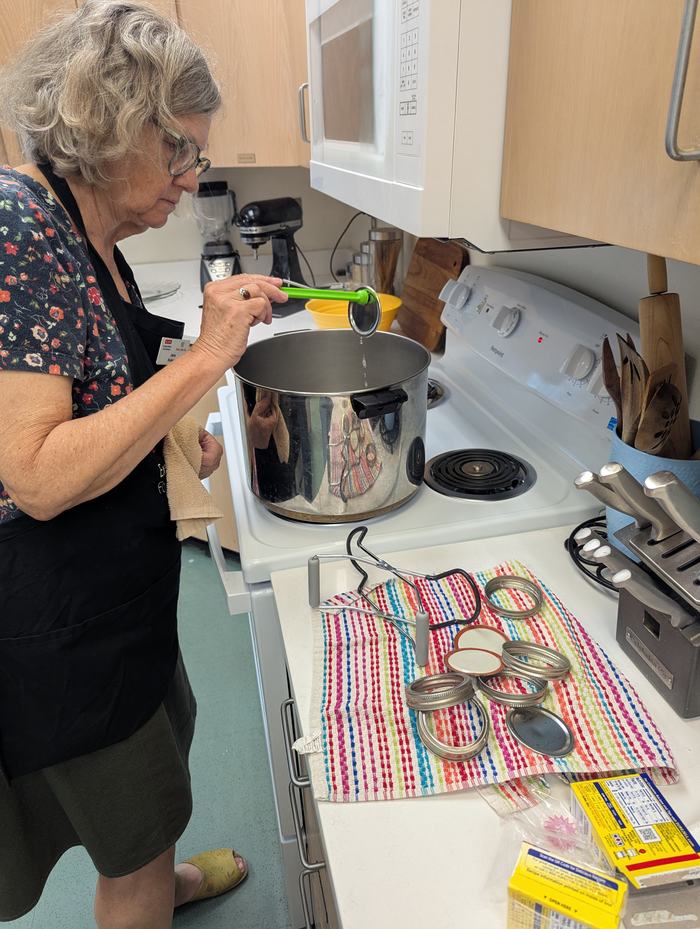 A woman sterilizes lids to be used in the canning process.
