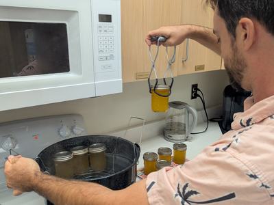 A man places cans in a pressure canner.
