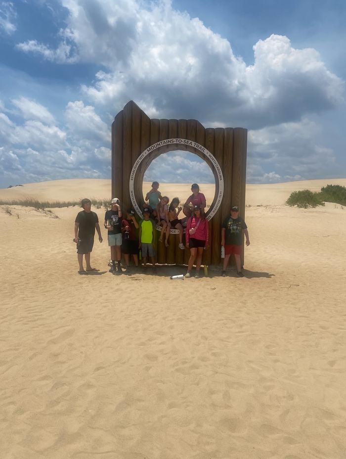Children posing with the Mountains to Sea Trail marker.