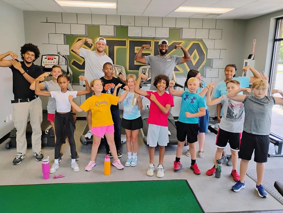 Students flex together in a group.