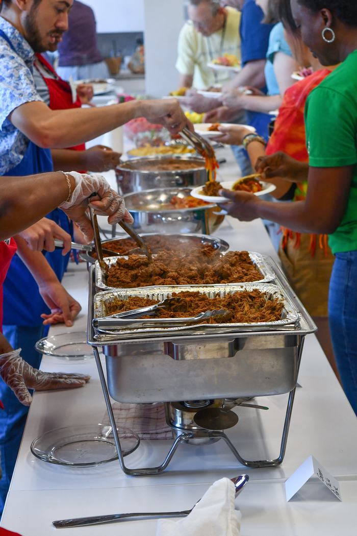 People being served hot food from steam tables in food lab