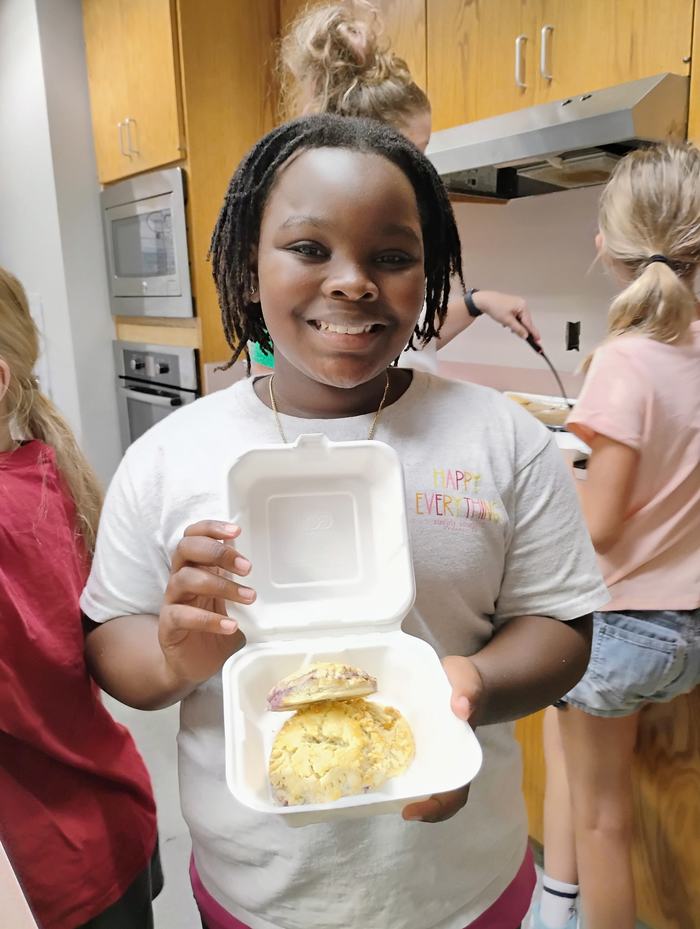 A student shows off items they have baked.