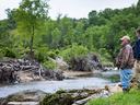 David Davis, director of the N.C. Cooperative Extension center in Yancey County, surveys the impact of Hurricane Helene on River Oak Farm in Burnsville, N.C., with owner Roger Young.
