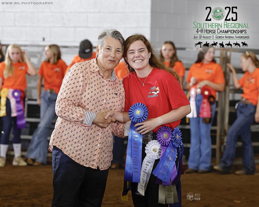 Woman presenting ribbons to smiling youth at 2025 Southern Regional 4-H Horse Championships
