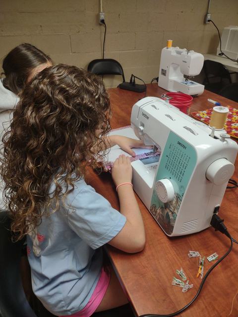 Girl using a sewing machine.