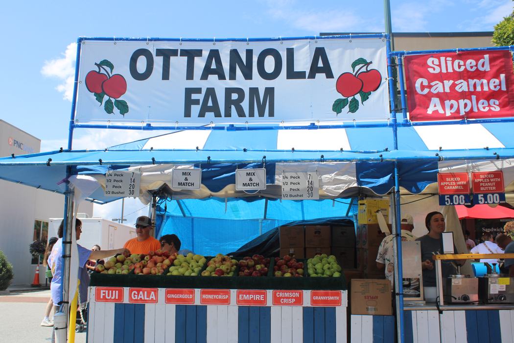 Ottanola Farm market stall with bins of apples and sign "Sliced Caramel Apples"