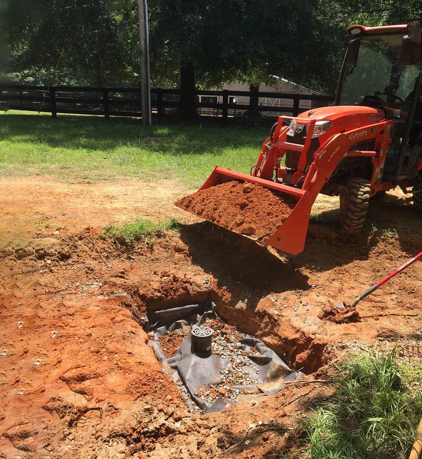 Covering a dry well with loose dirt.