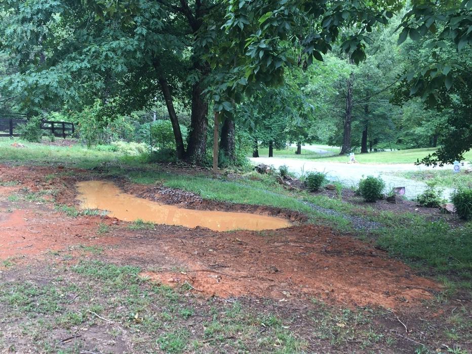 A water detention pond dug at the side of a drive.
