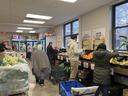 People selecting fruits and vegetables at an indoor community food pantry