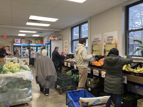 People selecting fruits and vegetables at an indoor community food pantry