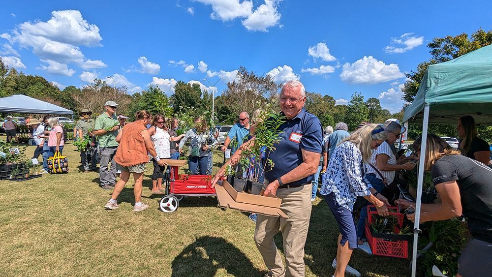 native plant sale customer holding recently purchased plants