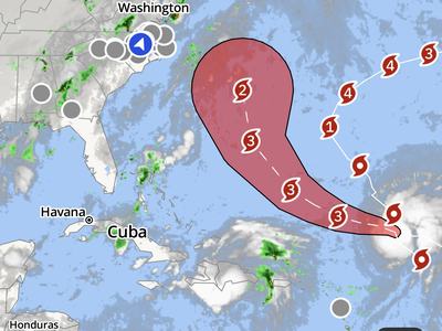 Hurricane forecast map showing a major storm tracking west-northwest across the Atlantic with projected intensification to Category 4 before curving northward off the U.S. East Coast. The forecast cone includes portions of the southeastern U.S. coast near