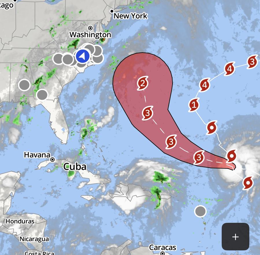 Hurricane forecast map showing a major storm tracking west-northwest across the Atlantic with projected intensification to Category 4 before curving northward off the U.S. East Coast. The forecast cone includes portions of the southeastern U.S. coast near North Carolina.
