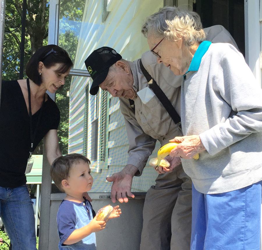 Volunteers delivering food to Meals on Wheels senior meals recipients at home.
