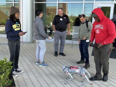 Extension agents looking at a robot