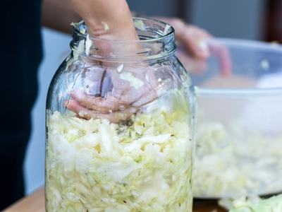 person making sauerkraut in a quart jar