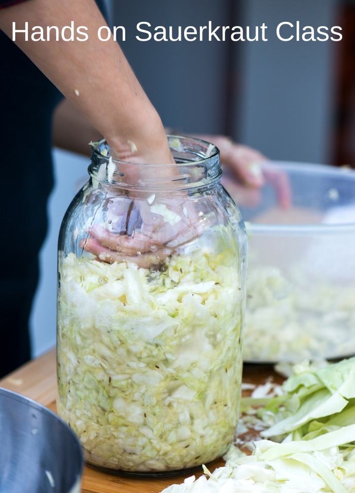person making sauerkraut in a quart jar
