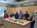 Volunteers stand in a teaching kitchen.