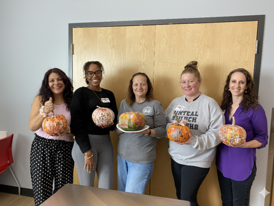 staff holding decorated pumpkins