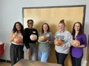 staff holding decorated pumpkins
