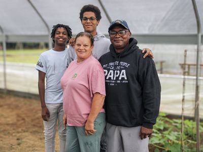 Timmy Taylor standing with his wife and grandkids