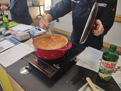Soup being stirred in a teaching kitchen.