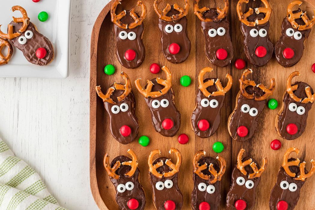 Reindeer cookies lined on a wooden tray.