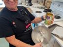 Person holding can labeled "Organic Garbanzo Beans" over mixing bowl with whisk