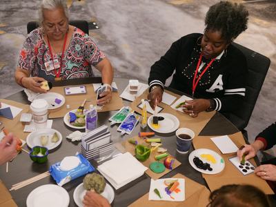 EFNEP educators practicing an actiivity using produce as a stamp to make art